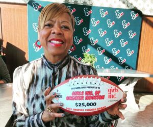 CEO Treopia Cannon holding award ball grant from Texans Foundation