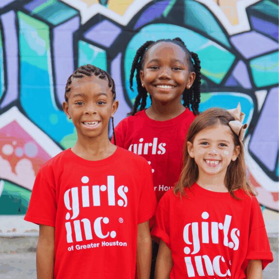 three smiling girls with GIGH tshirts on